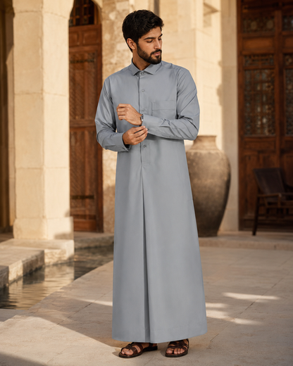 Silver Mist Thobe by Al-Emara, featuring a traditional long Islamic garment in elegant silver fabric, displayed on a hanger.