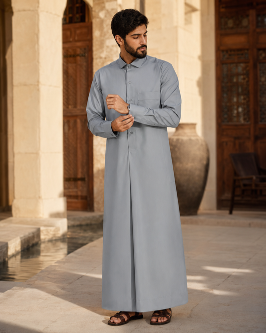 Silver Mist Thobe by Al-Emara, featuring a traditional long Islamic garment in elegant silver fabric, displayed on a hanger.