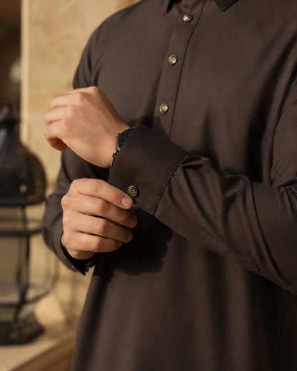 Elite chocolate brown thobe by Al-Emara displayed on a mannequin, showcasing traditional Islamic men's attire with detailed embroidery.