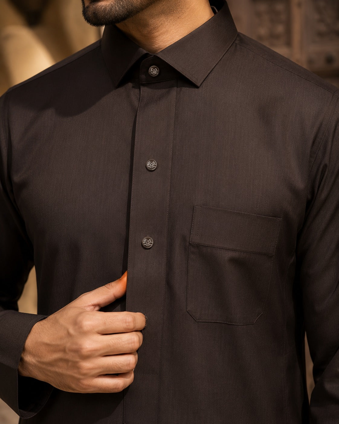 Elite chocolate brown thobe by Al-Emara, featuring traditional Islamic attire with a long, flowing design and intricate embroidery.